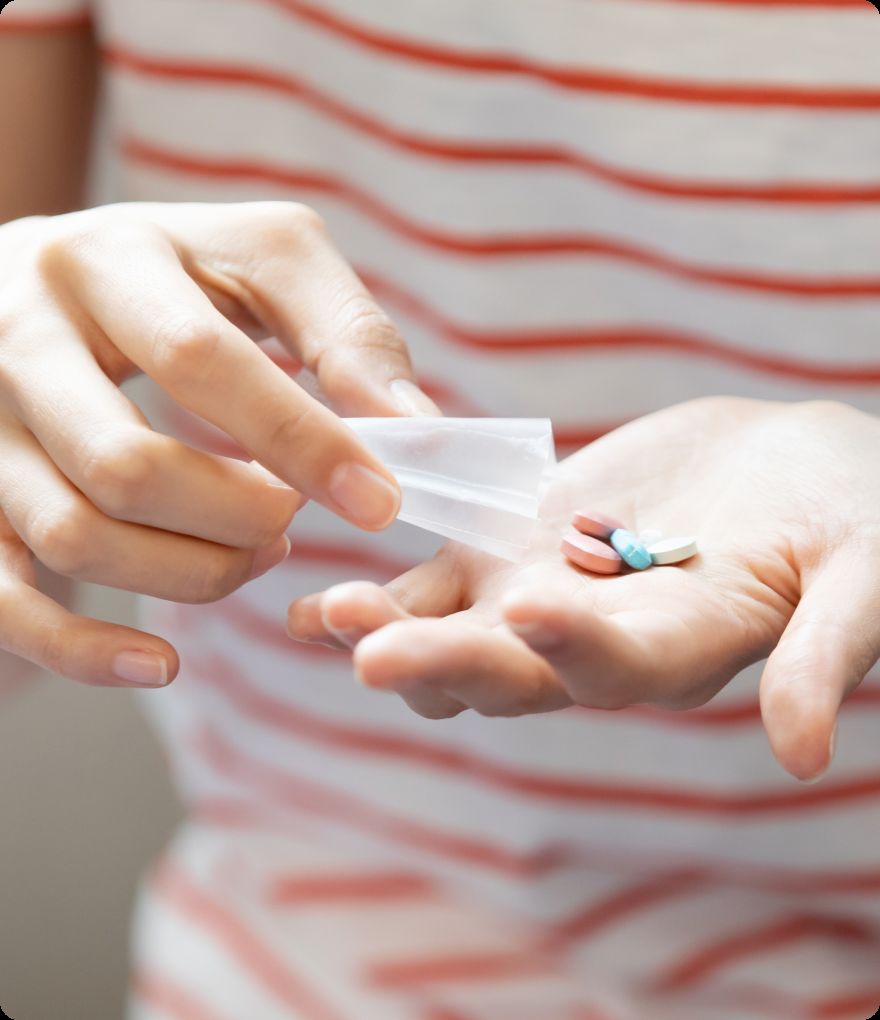 Tablets being poured from a dispensed medication pouch into a palm